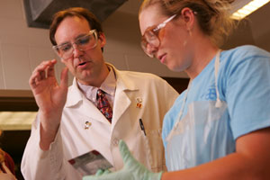 Christopher Dunlap, associate professor of chmistry, works with a student in the lab.