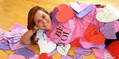 Laura Glaub '12, creator of "Love Your Body Week" poses in a "Be-You-tiful" t-shirt.